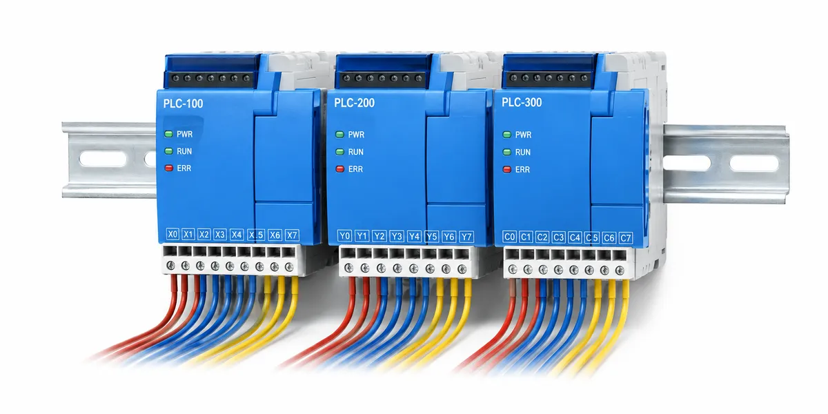 DIN rayında PLC modüllerinin yerleşim düzeni Beyaz zeminde gümüş DIN rayına dizilmiş mavi PLC modülleri ve taranmış renkli klemens kabloları